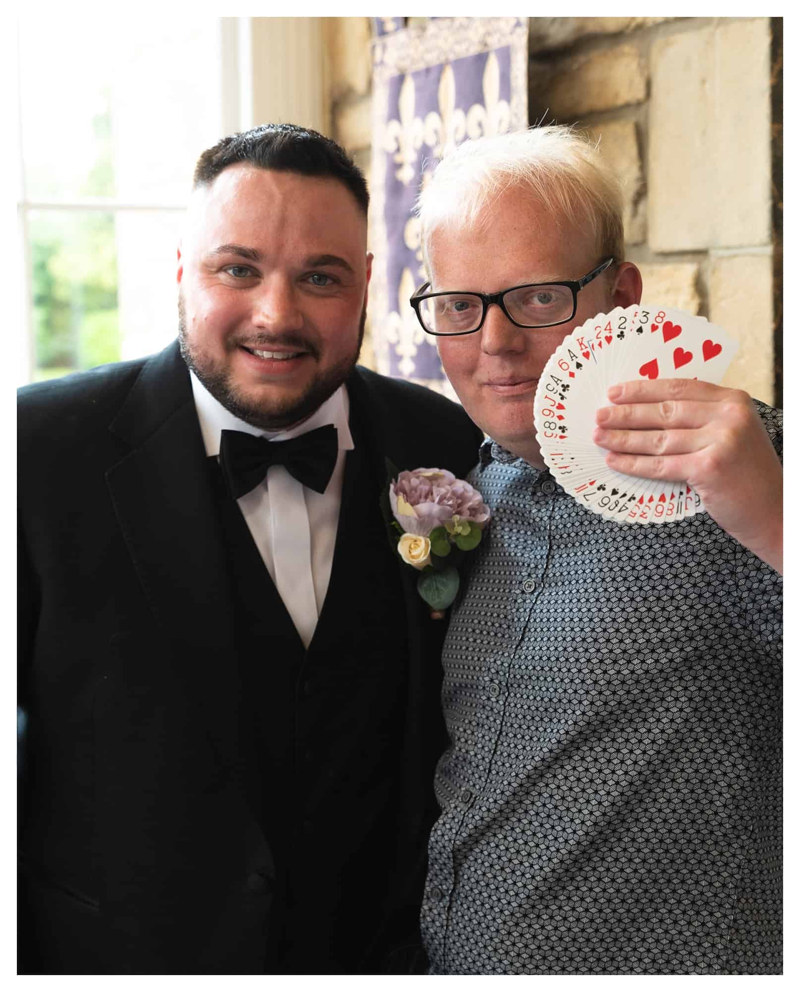 picture of paul dawson magician, with the groom holding a pack of cards