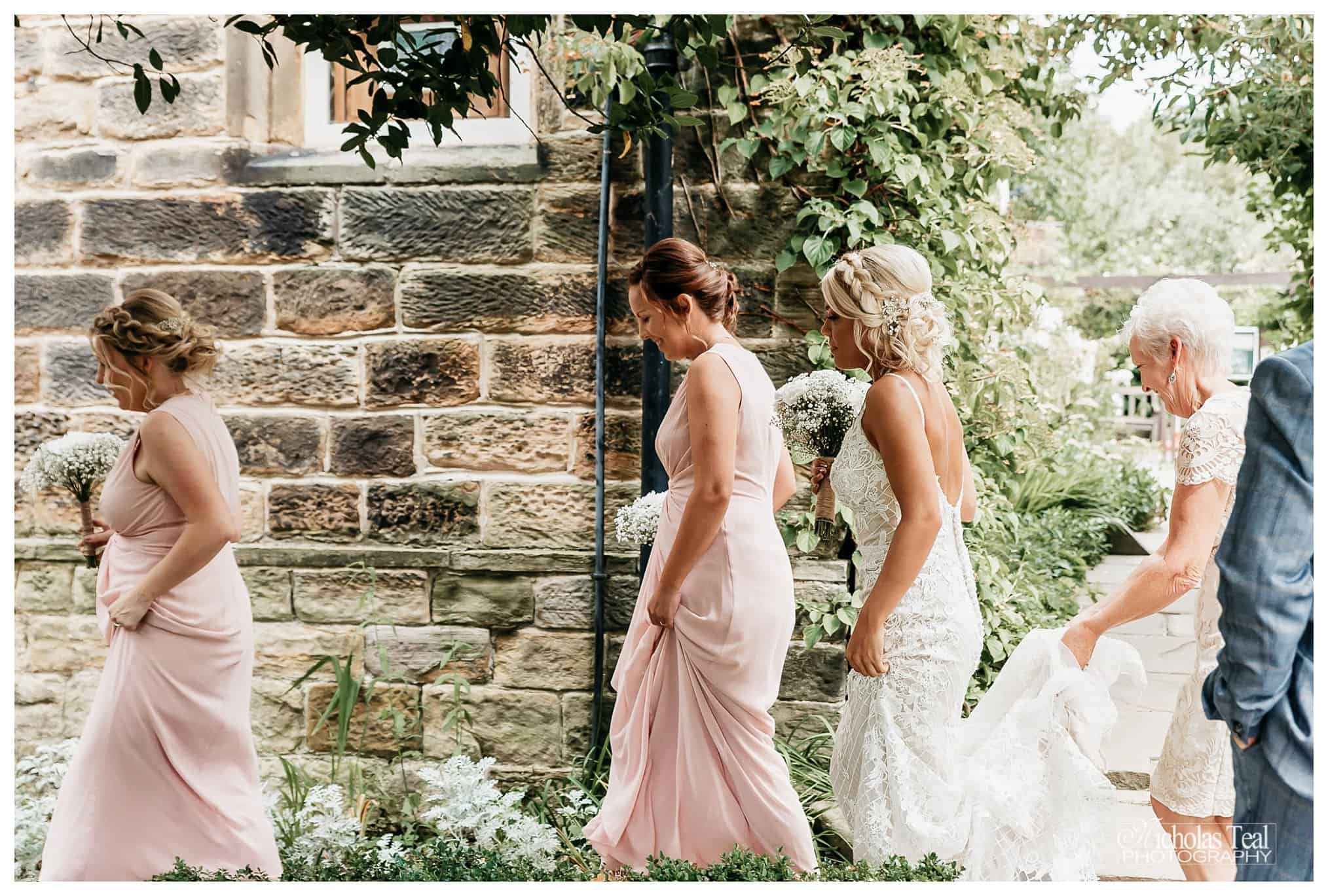 Bride been helped into hall by bridesmaids just before service Oakwell Hall Batley , Oakwell hall Wedding Photos, Oakwell Hall Wedding Photographer