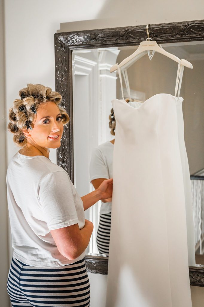 this images shows the bride holding her wedding dress up