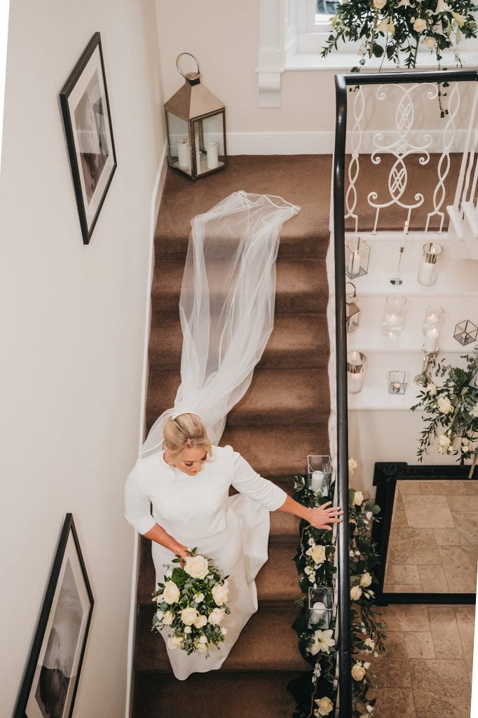 alternative angle of bride walking down stairs to see her father