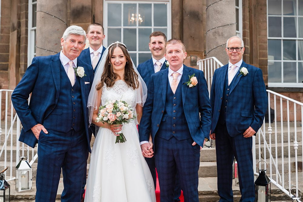 Groomsmen with bride posed group shot on steps outside wood hall hotel red-carpet, Wood Hall Hotel, Wetherby , wood hall hotel Wetherby wedding photography