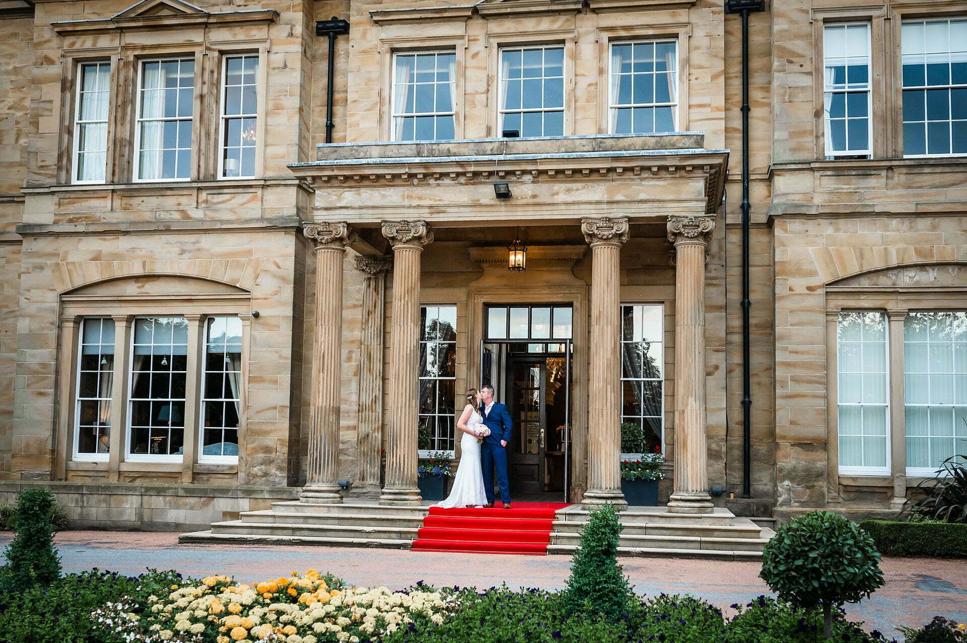 bride and Groom posing in front of Hall Doorway Oulton Hall Hotel Wedding Photos, Oulton Hall Hotel Wedding Photographer