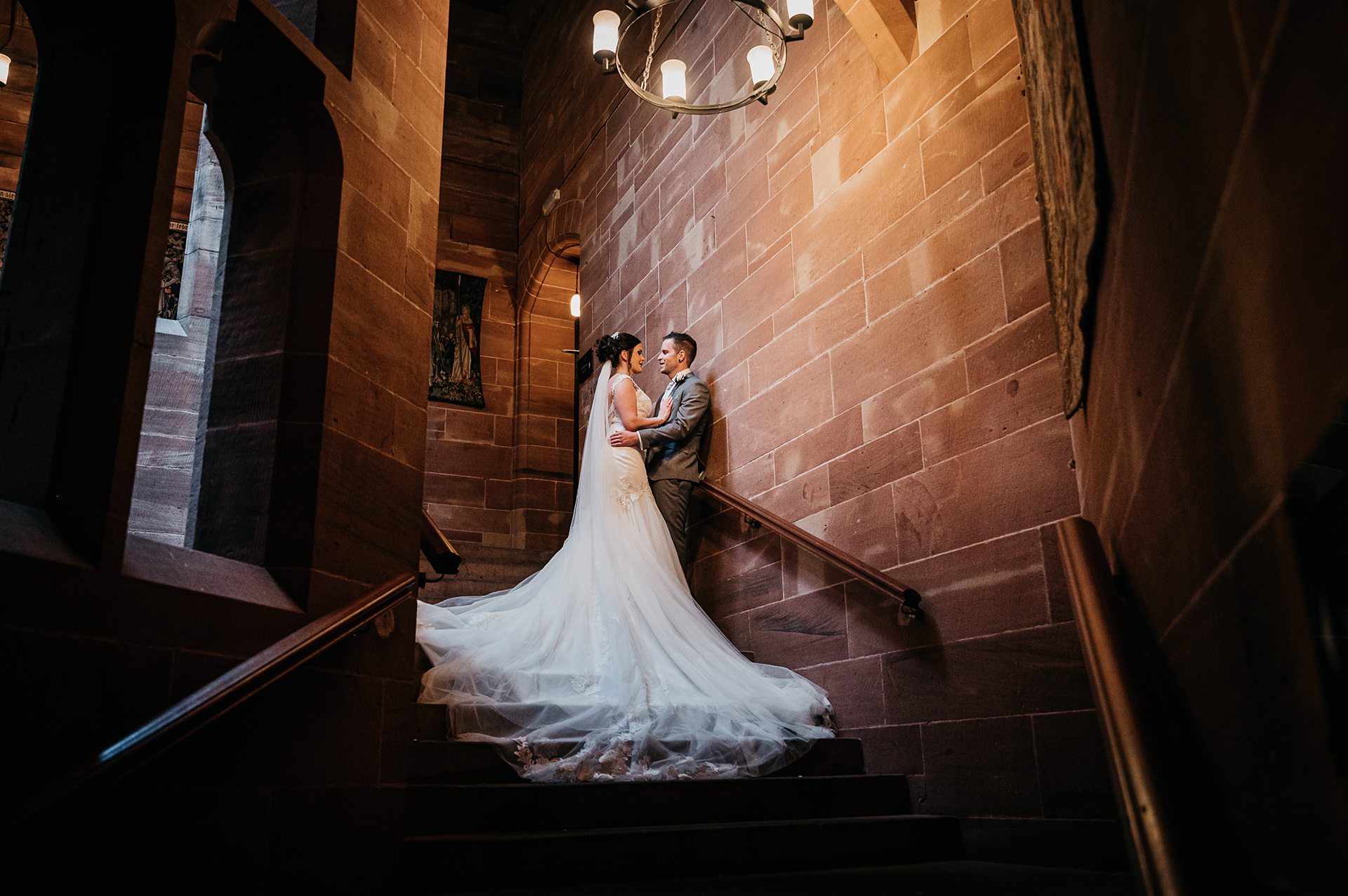 photo bride and groom posing on winding staircase inside the castle