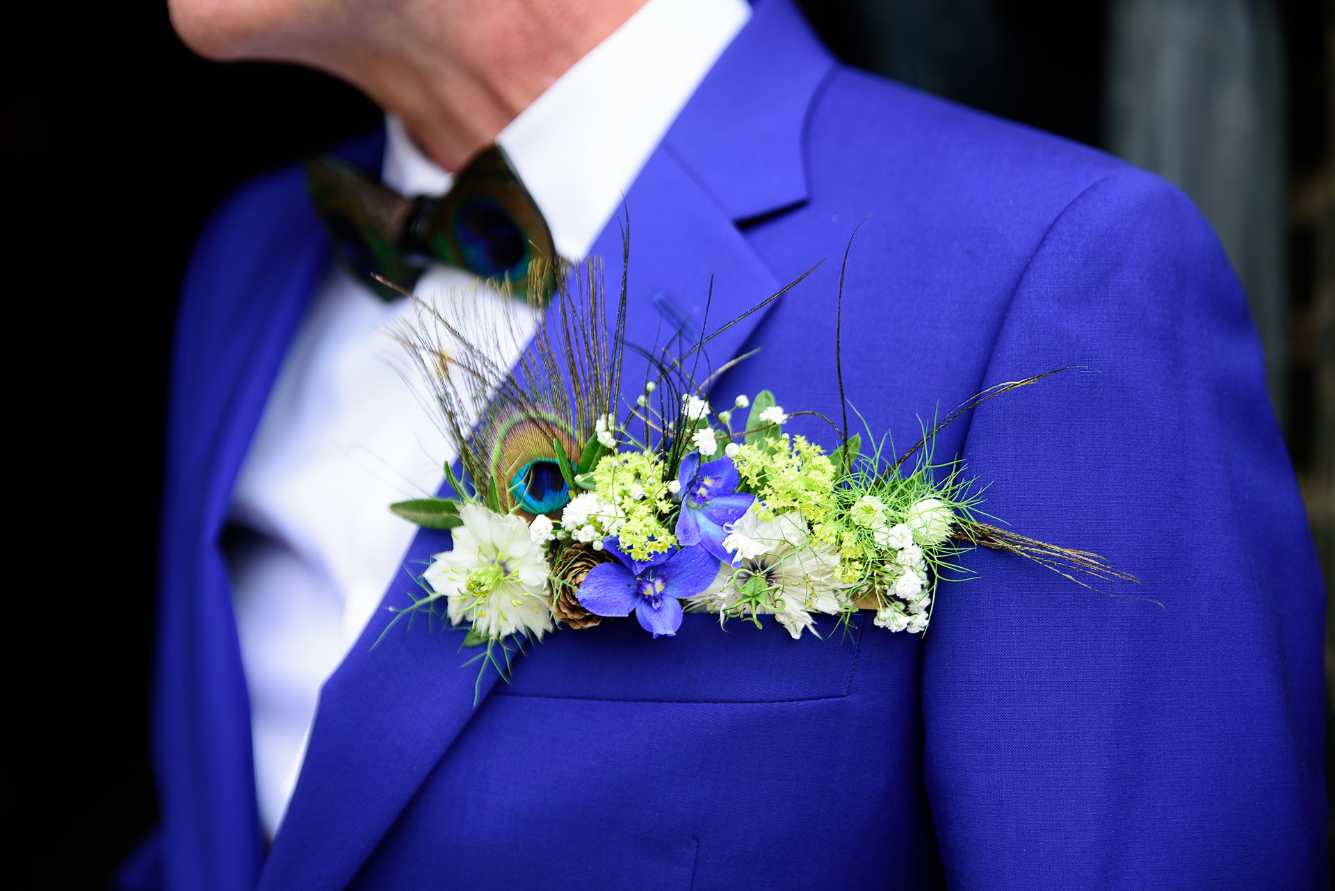 picture of grooms buttonhole featuring peacock feathers