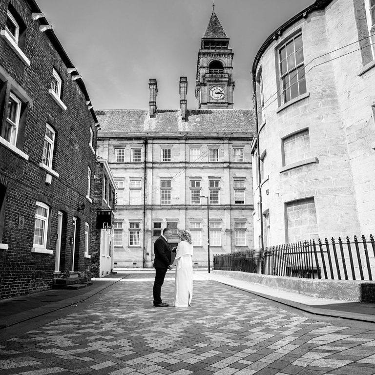 Wakefield wedding venue guide, this image show a bride and groom posing in Wakefield city center street