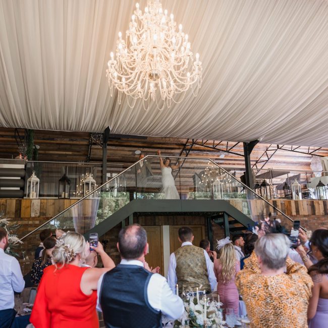 bride and groom make their etrance into the barn while there guest all cheer