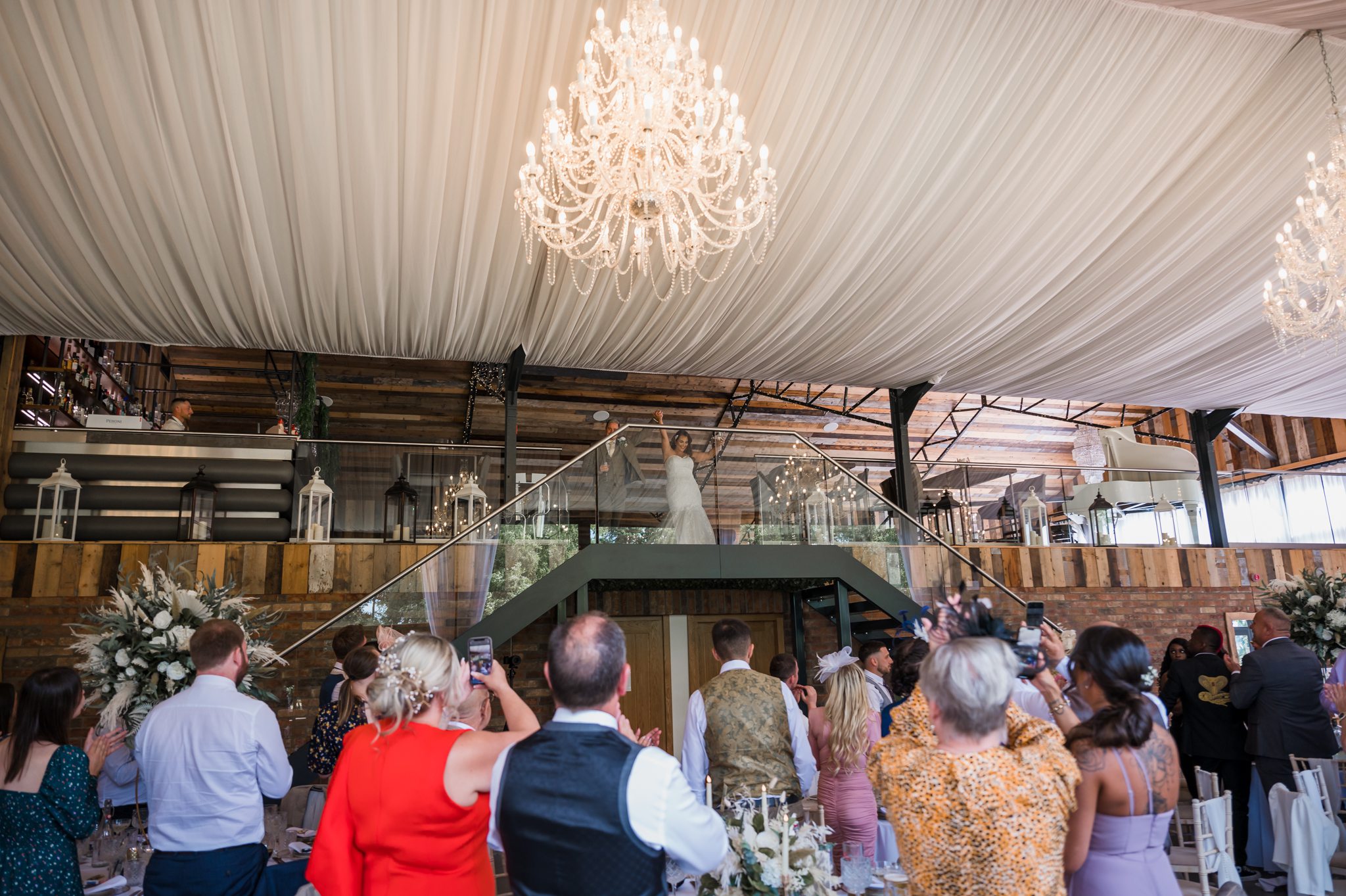 bride and groom make their etrance into the barn while there guest all cheer
