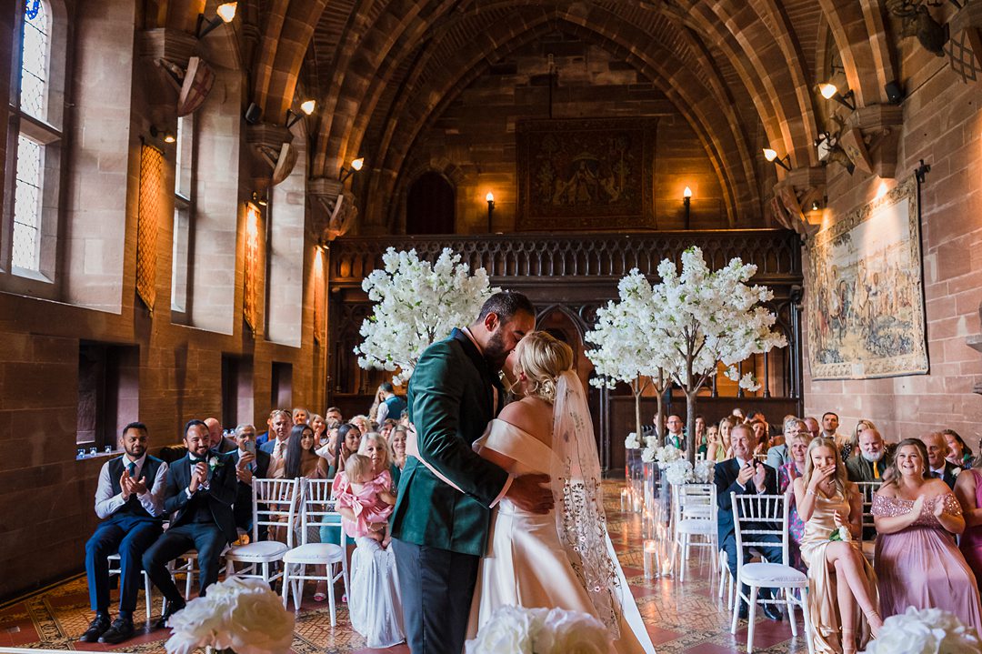 bride and groom kissing inside the great hall peckforton castle