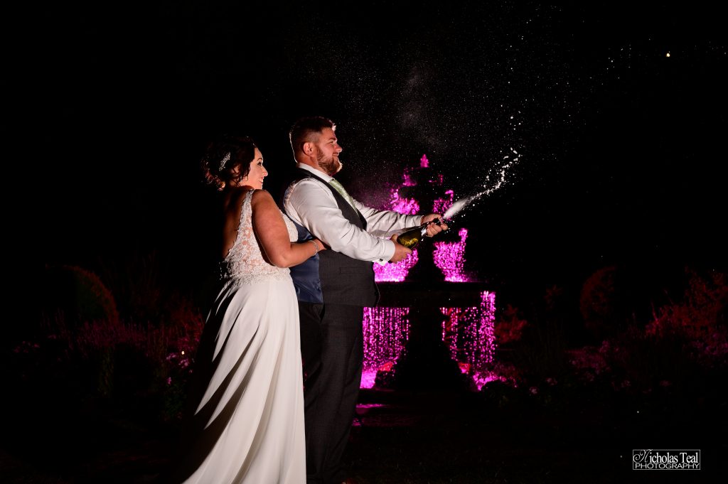 Bride and groom pose next to water fountain in Harrogate