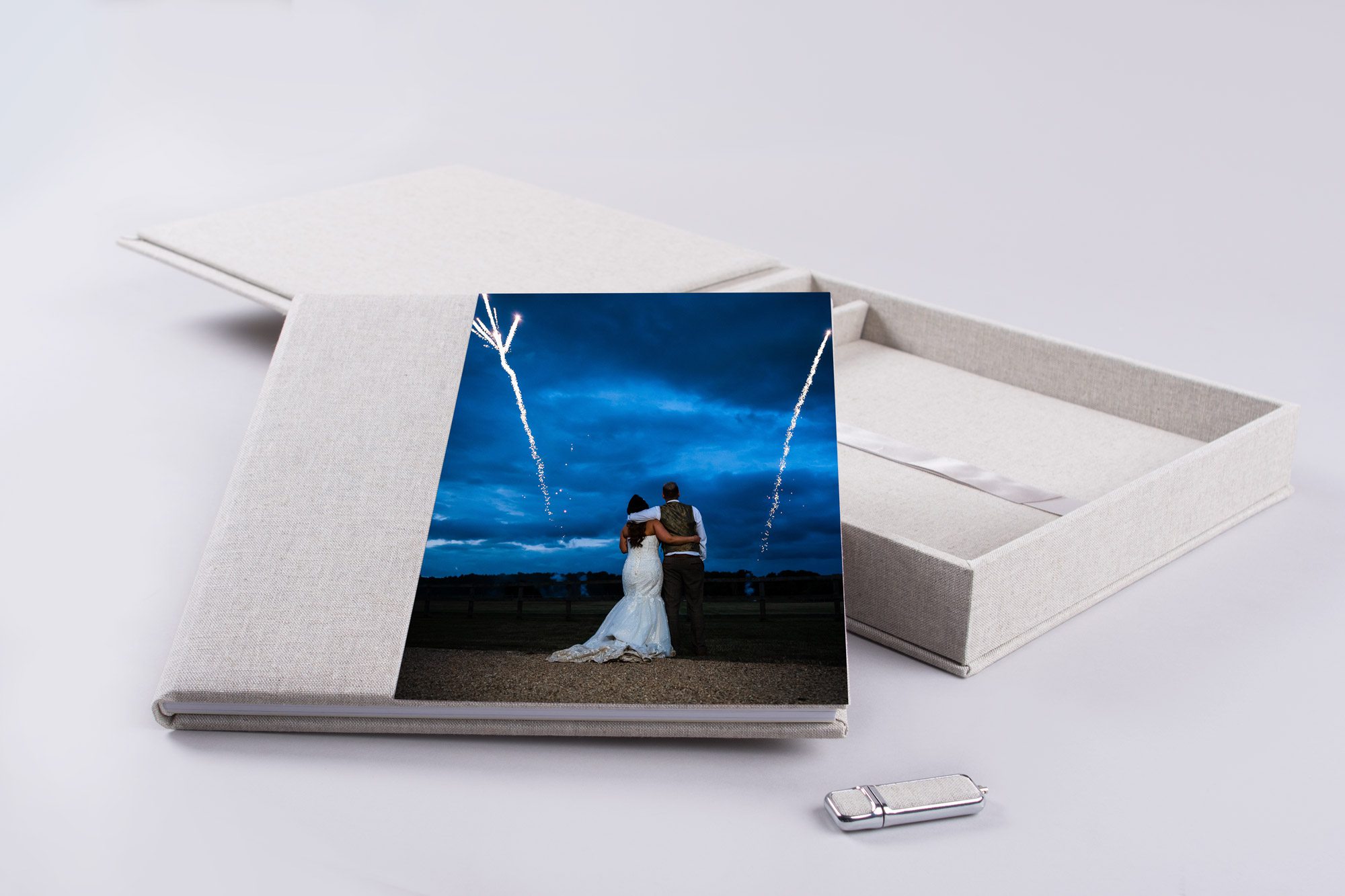 Luxury fine art wedding album open on table showcasing double page spread