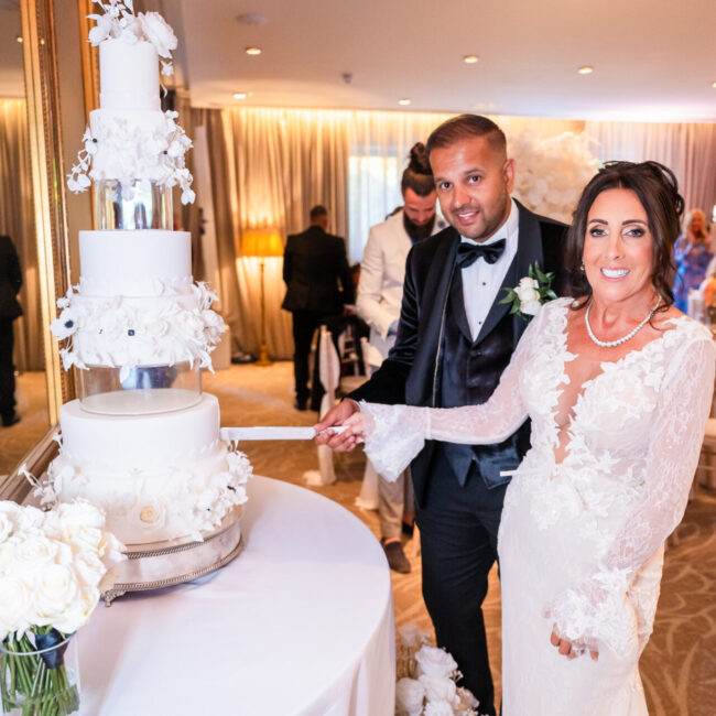 Bride and groom cutting their four-tier wedding cake at Grantley Hall, luxury Yorkshire wedding.