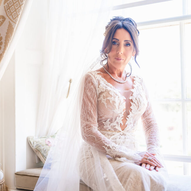 Beautiful bridal portrait of the bride sitting in the window of the Royal Suite at Grantley Hall.