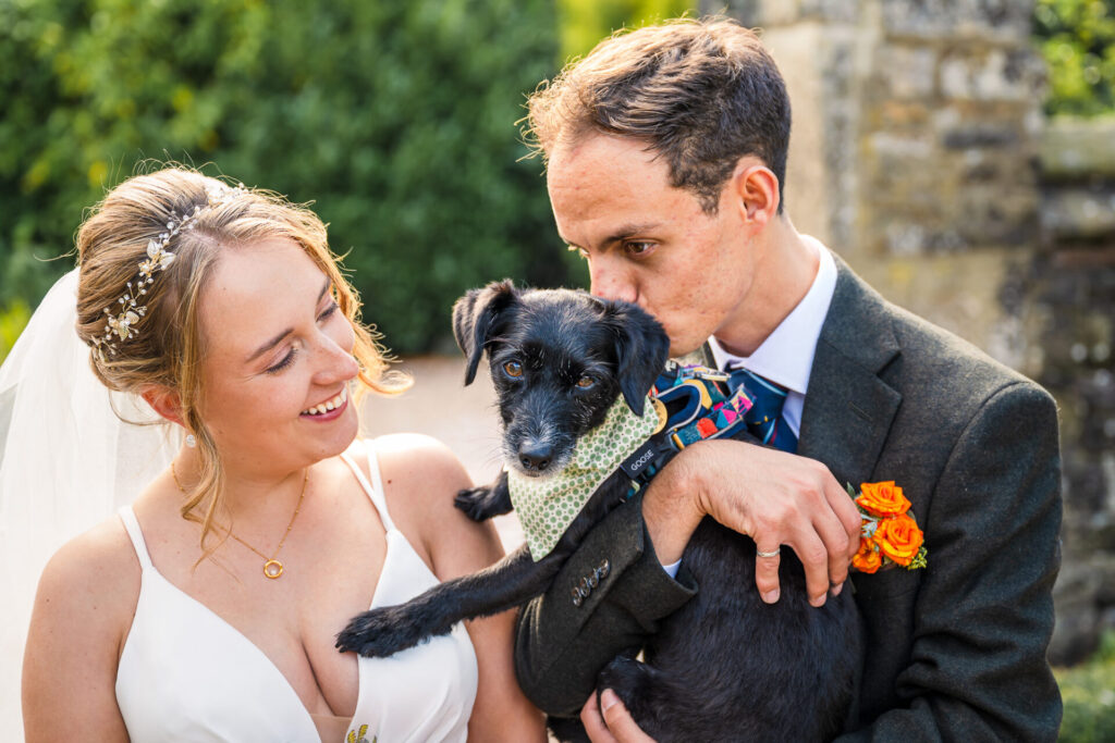 bride and groom kissing there dog , Holdsworth house is pet friendly