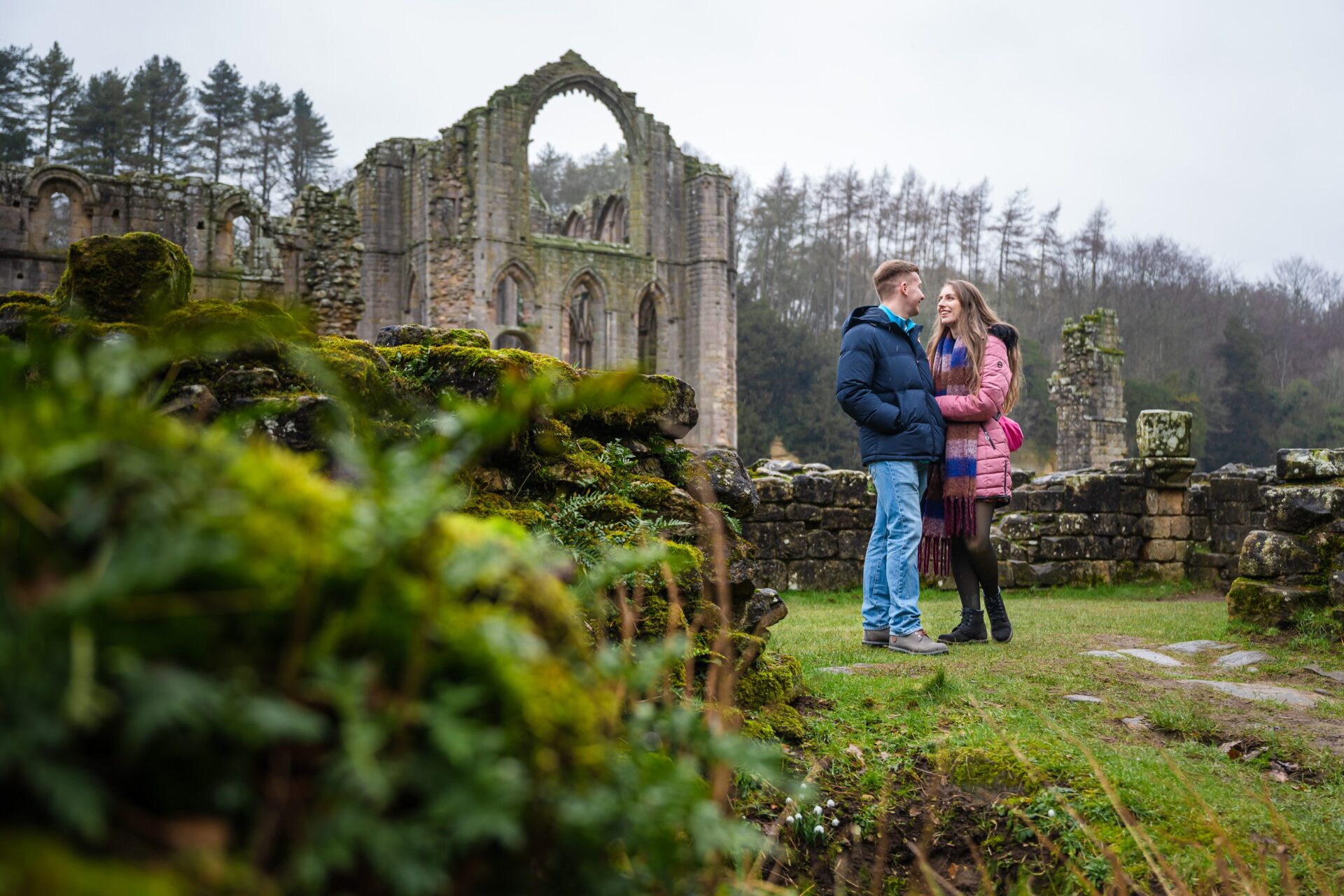 Couple at historic Yorkshire abbey ruins, cinematic engagement photography, romantic mood.